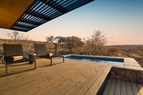 a deck with two chairs and a swimming pool at 57 Waterberg in Welgevonden Game Reserve