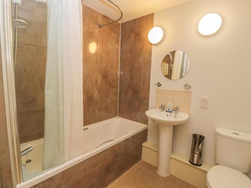 een badkamer met een douche, een wastafel en een toilet bij The Moorings in Isle of Whithorn