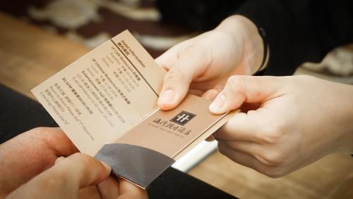 a person cutting a piece of paper with a knife at HiONE Holiday Hotel in Shenkeng