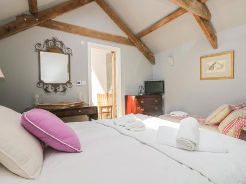 a bedroom with a large white bed with purple pillows at Little Chycoose in Truro