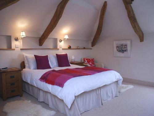 a bedroom with a large bed in a attic at The Linhay in Throwleigh