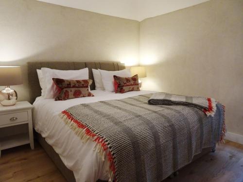 a bedroom with a large bed with pillows at Rock View Cottage in Gunnislake