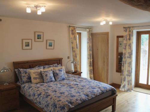 a bedroom with a bed and two lamps and a window at Swallows Reach in Halwell