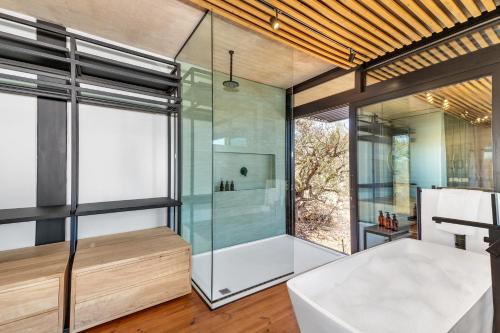 a bathroom with a glass shower and a tub at 57 Waterberg in Welgevonden Game Reserve