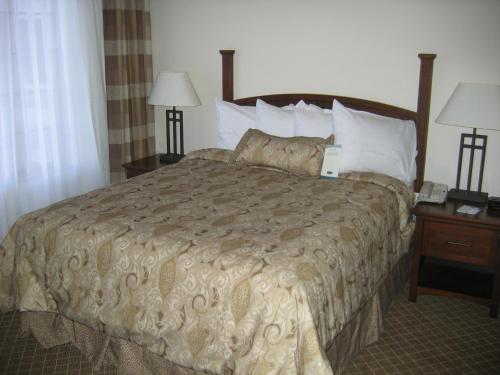 a bed in a hotel room with two night stands and two lamps at Staybridge Suites Indianapolis-Airport, an IHG Hotel in Plainfield