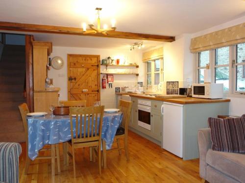 una cocina con mesa y mantel azul. en The Linhay, en Throwleigh