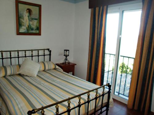 a bedroom with a bed and a large window at La Almena in La Iruela