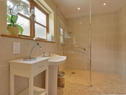 y baño con lavabo y ducha. en 2 Shippen Cottages en Cotleigh