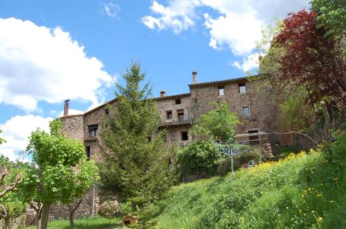 un antiguo edificio de piedra en la cima de una colina en Can Salgueda, en Santa Pau