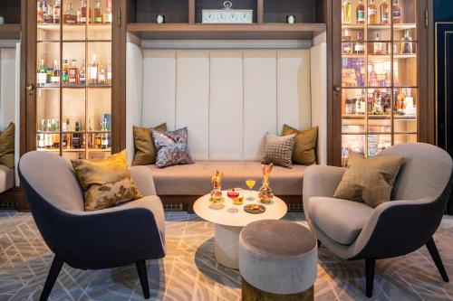 a living room with a couch and two chairs and a table at Fraser Suites Hamburg in Hamburg
