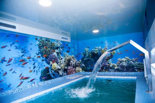 a room with a swimming pool and an aquarium at Premier Hotel in Kostroma