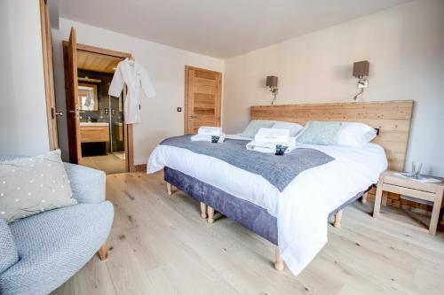 een slaapkamer met een groot bed en een bank bij Les Roches Noires in Morzine