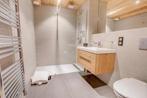 une salle de bain avec une douche, un lavabo et des toilettes dans l'établissement Les Roches Noires, à Morzine