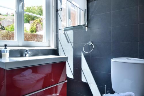 Un baño con lavabo, inodoro y ventana. en Oeiras 3 - Checkinhome, en Oeiras