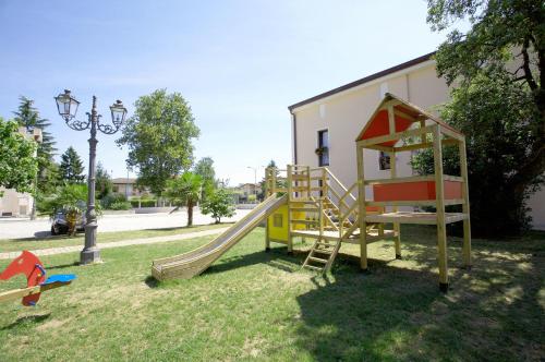 a playground with a slide and a play house at Hotel Al Barco in Santo Stino di Livenza