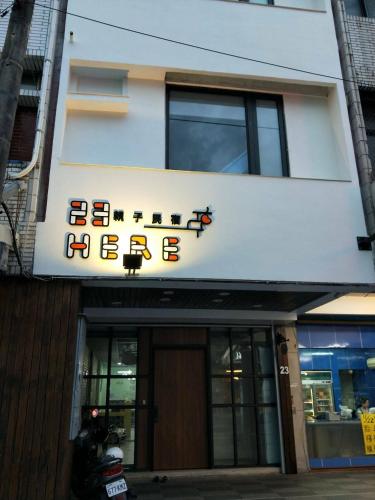 a building with a sign that reads here at 23 Here B&B in Hualien City