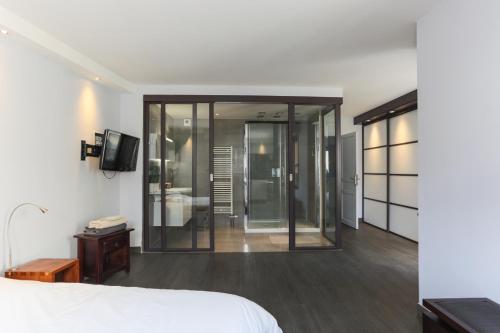 ein Schlafzimmer mit einem Bett und einem TV sowie ein Zimmer in der Unterkunft PEACE&LOFT: JACUZZI & TERRASSE in Versailles