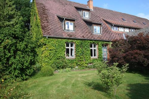 a house covered in ivy with a yard at Gemütliche Premium Öko Ferienwohnung in Resthof, super ausgestattet, keine Handwerker und Monteure in Sterley