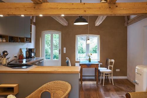 uma cozinha com um balcão, uma mesa e cadeiras em Gemütliche Premium Öko Ferienwohnung in Resthof, super ausgestattet, keine Handwerker und Monteure em Sterley