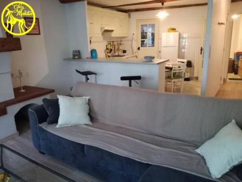 uma sala de estar com um sofá e uma cozinha em Chez Makita - RdC em Mirepeisset