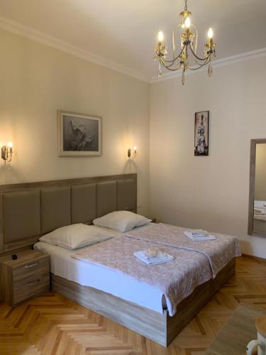 Schlafzimmer mit einem Bett und einem Kronleuchter in der Unterkunft Guest House Rafael in Tbilisi City