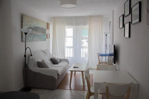 ein Wohnzimmer mit einem Sofa und einem Tisch in der Unterkunft centrico apartamento nuevo, zona corte ingles in Málaga