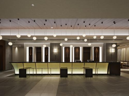 a large lobby with a long table and chairs at Hotel JAL City Sapporo Nakajima Park in Sapporo
