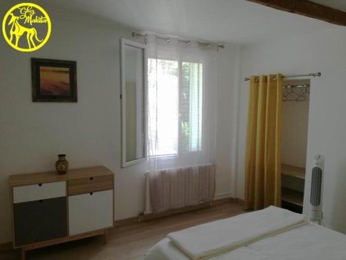 um quarto com uma cama, uma cómoda e uma janela em Chez Makita - RdC em Mirepeisset