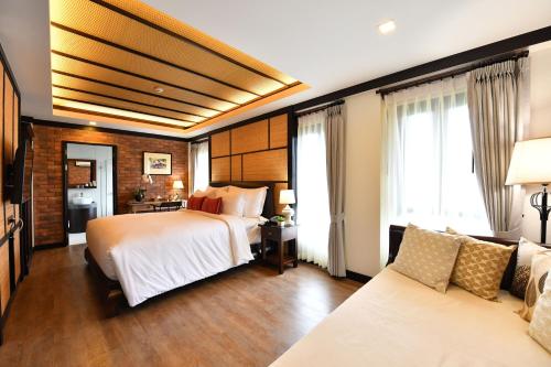 a hotel room with a bed and a couch at El Barrio Lanna in Chiang Mai