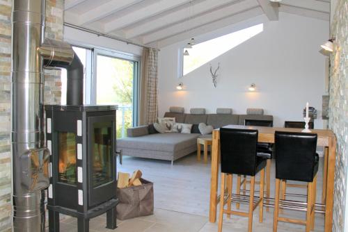 a living room with a fireplace and a table with chairs at Ana's Landhaus auch für Monteure in Heretsried