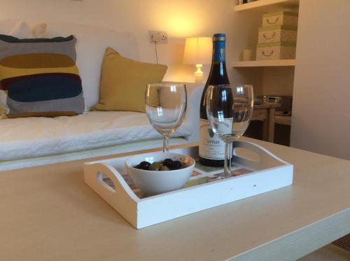 a bottle of wine and two wine glasses on a table at Perfect for Caernarfon Castle, Snowdon, & Zip World in Caernarfon
