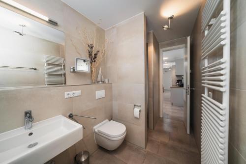 a bathroom with a white sink and a toilet at Ferienwohnung Ostseeblick WE 15 Villa Seeadler in Börgerende-Rethwisch