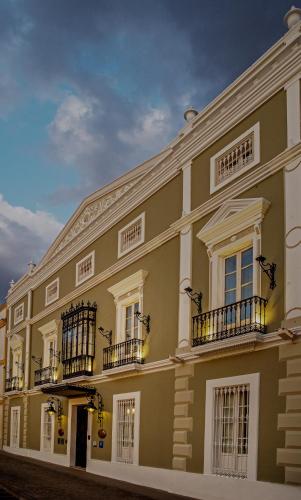 a large building with balconies on a street at Hotel Boutique Conde de la Corte in Zafra