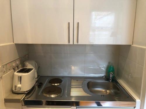 a small kitchen with a sink and a toaster at Stylish Studio Room in Brixton - E in London