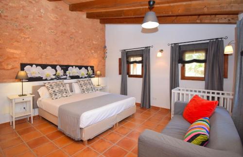 a bedroom with a bed and a couch at Finca Siscelis 063 by Mallorca Charme in Santa Maria del Camí