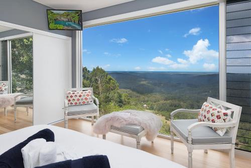a bedroom with a large window with chairs and a bed at 629 Balmoral Ridge in Balmoral Ridge