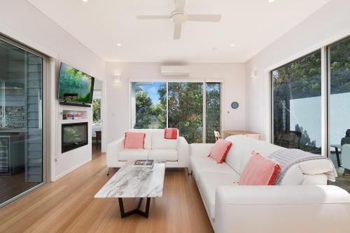a living room with white furniture and large windows at 629 Balmoral Ridge in Balmoral Ridge