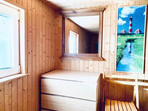 eine Sauna mit einer Bank, einem Spiegel und einem Leuchtturm in der Unterkunft Ferienpark Vislust Ferienhaus Balu mit eigenem Steiger zum angeln Ijsselmeer Niederlande in Wervershoof