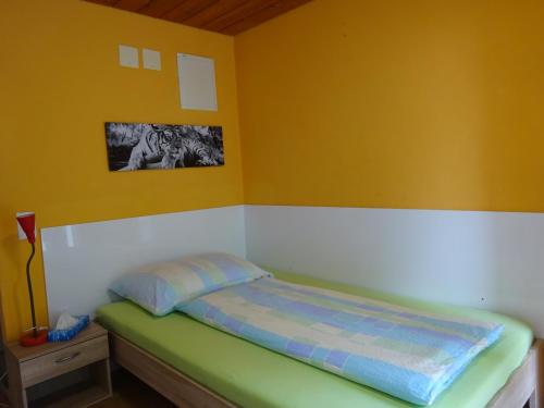 uma cama num quarto com paredes amarelas em Motel City em Spreitenbach