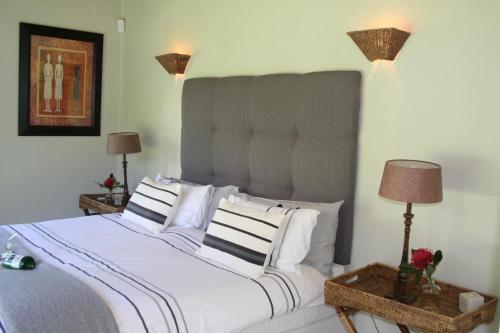 sypialnia z dużym białym łóżkiem z białymi poduszkami w obiekcie The Cottage on 55 w mieście Franschhoek