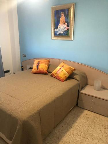 a bedroom with a bed with a painting on the wall at El Balcón de Sevilla in Seville