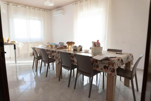 a dining room with a long table and chairs at LA CASA DI MAMMA 'NTO in Castrofilippo