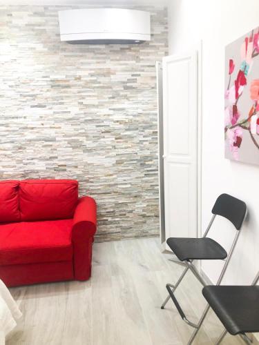 - un salon avec un canapé rouge et une chaise dans l'établissement Delizioso Appartamento in Via di Monte Verde, à Rome