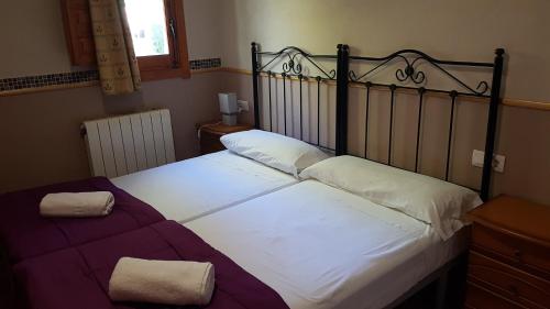a bedroom with a large bed with white sheets at Camping Ruta del Purche in Monachil