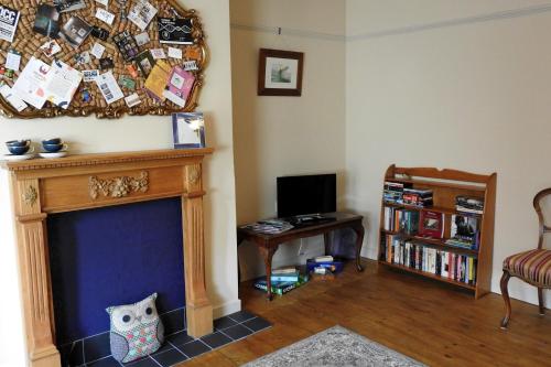 a living room with a fireplace and a tv at Heatopia Apartment in Newcastle upon Tyne