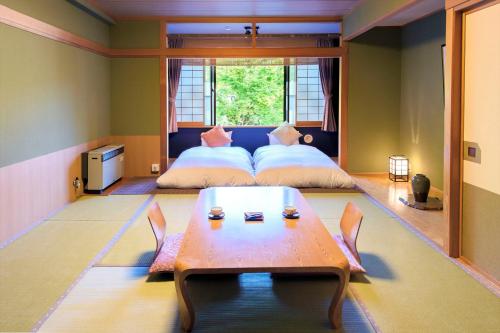 1 dormitorio con 2 camas y una mesa en el centro en Meitoya So en Zao Onsen