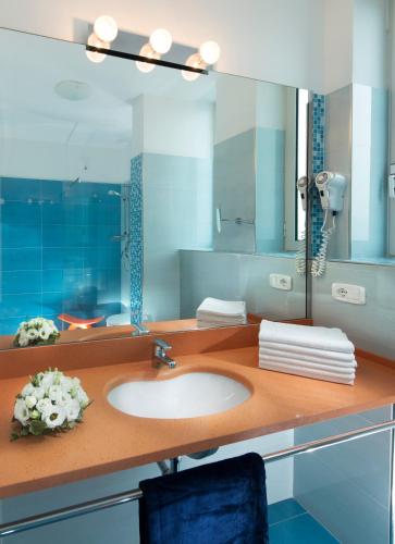 a bathroom with a sink and a mirror at Hotel Parigi in Bibione