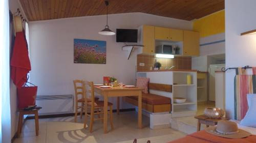 une petite cuisine et salle à manger avec une table et des chaises dans l'établissement VVF Luberon Provence, à Murs