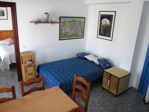 Apartamento Terranova La Placeta في ألاما دي غرانادا: غرفة نوم صغيرة بسرير ازرق وطاولة