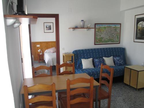 Apartamento Terranova La Placeta في ألاما دي غرانادا: غرفة معيشة مع أريكة زرقاء وطاولة